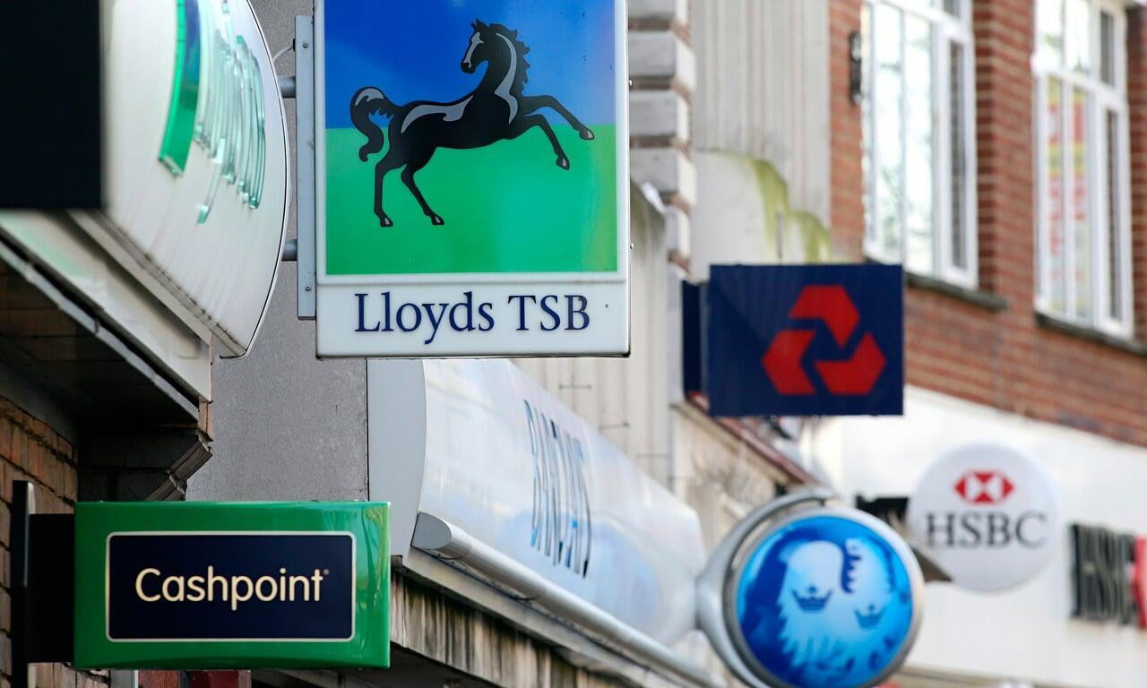 bank signs hanging from the side of a town high street